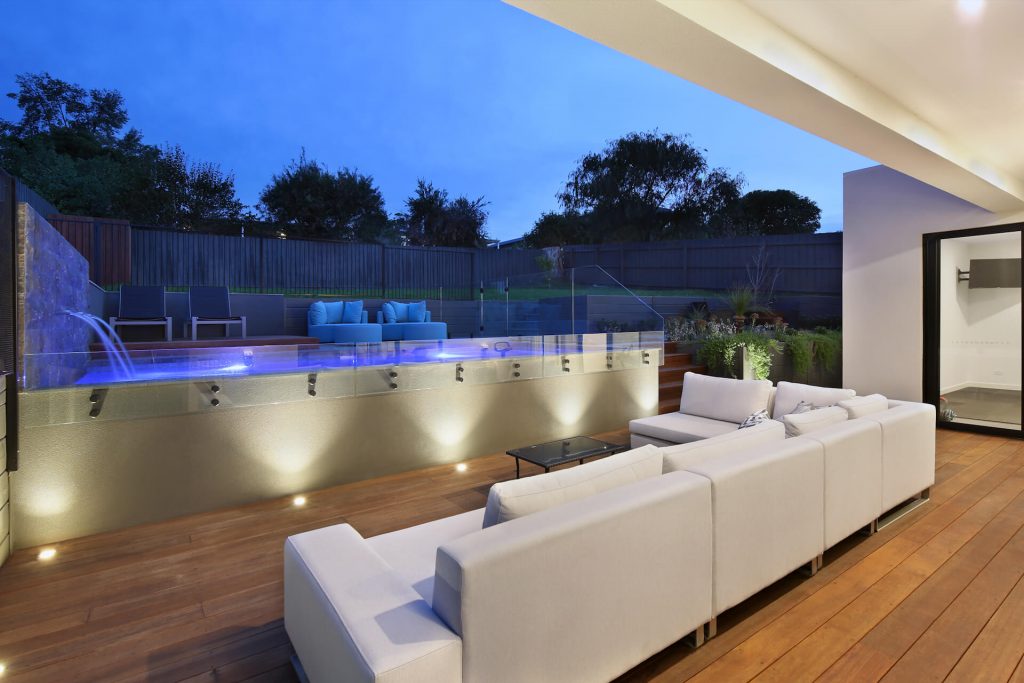 designer outdoor area with timber decking and feature lighting